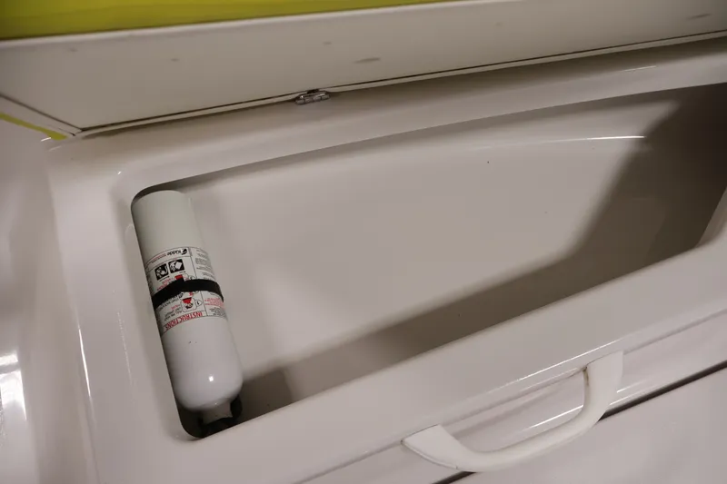 Slide: The Image of Open storage compartment in 2017 Scarab 165 G boat with fire extinguisher. - 14