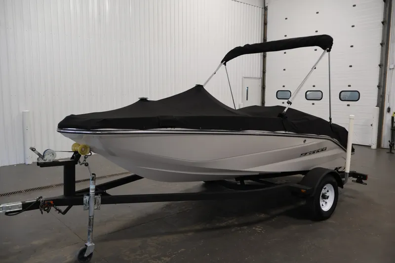 Slide: The Image of 2017 Scarab 165 G boat with black cover on trailer in indoor setting. - 33