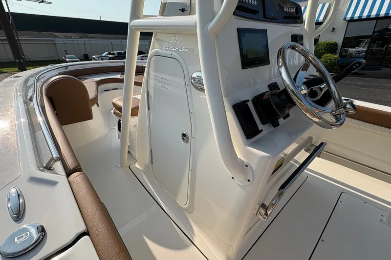 Slide: The Image of 2027 Pioneer 222 Islander boat interior with steering wheel and seating area. - 21