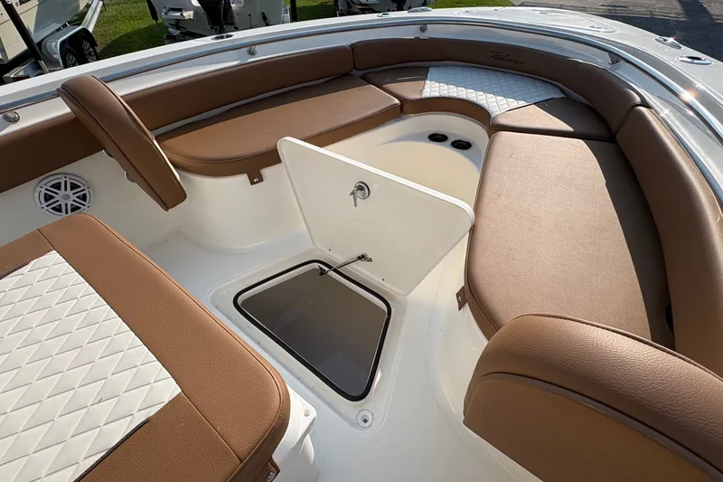 Slide: The Image of 2027 Pioneer 222 Islander boat interior with brown seating and storage compartment. - 28