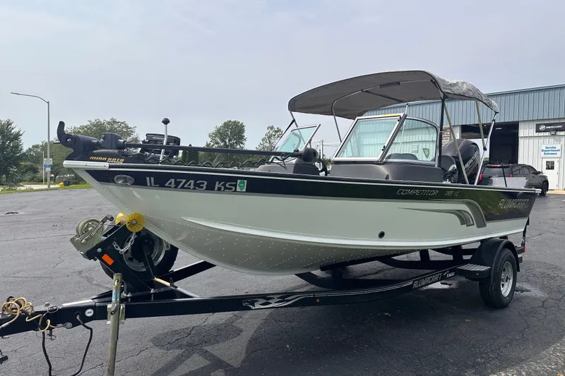Slide: The Image of 2013 Alumacraft Competitor 185 Sport boat on trailer, parked outdoors. - 2