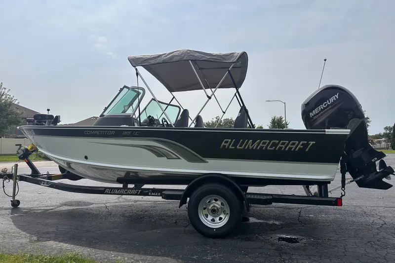 Slide: The Image of 2013 Alumacraft Competitor 185 Sport boat on trailer with Mercury outboard motor. - 3