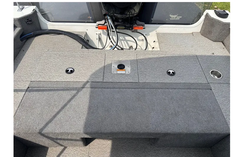 Slide: The Image of 2013 Alumacraft Competitor 185 Sport boat interior with carpeted deck and storage compartments. - 12