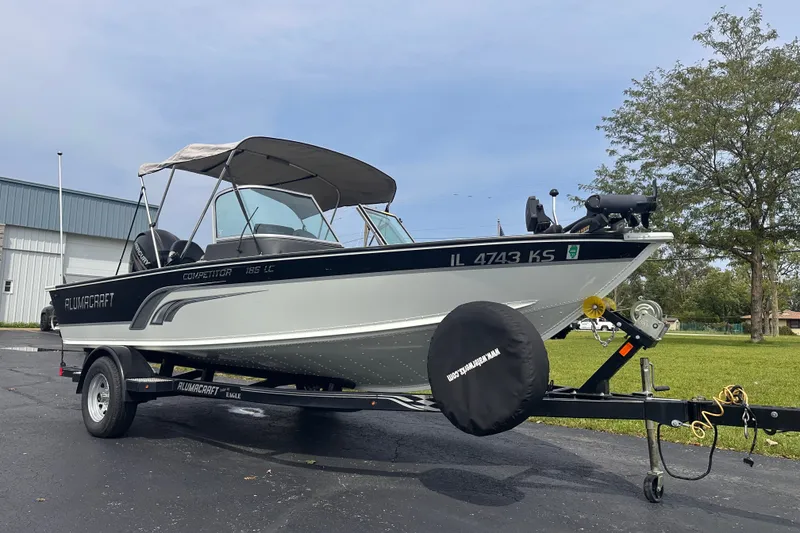 The Image of 2013 Alumacraft Competitor 185 Sport boat on trailer, parked outdoors. - 0