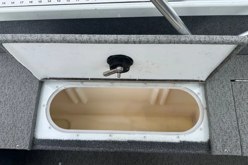 Slide: The Image of Open storage compartment in 2013 Alumacraft Competitor 185 Sport boat, featuring a ruler and latch. - 24