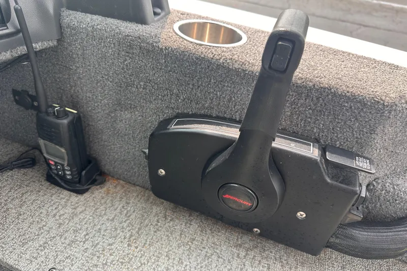 Slide: The Image of 2013 Alumacraft Competitor 185 Sport boat throttle control and radio on carpeted surface. - 20