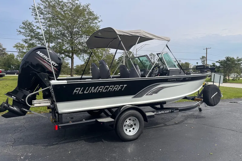 Slide: The Image of 2013 Alumacraft Competitor 185 Sport boat on trailer with Mercury outboard motor. - 1