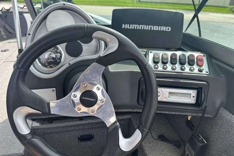 Slide: The Image of 2013 Alumacraft Competitor 185 Sport dashboard with steering wheel and Humminbird electronics. - 14