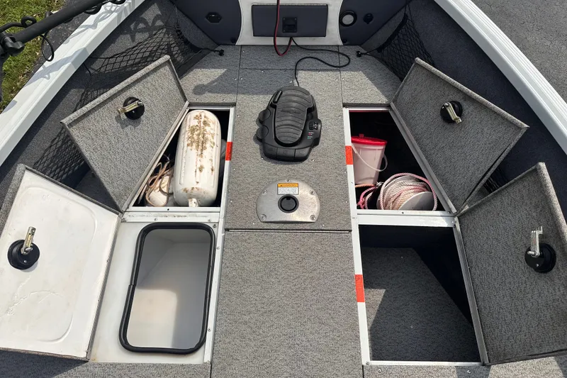 Slide: The Image of 2013 Alumacraft Competitor 185 Sport boat storage compartments with various equipment. - 11