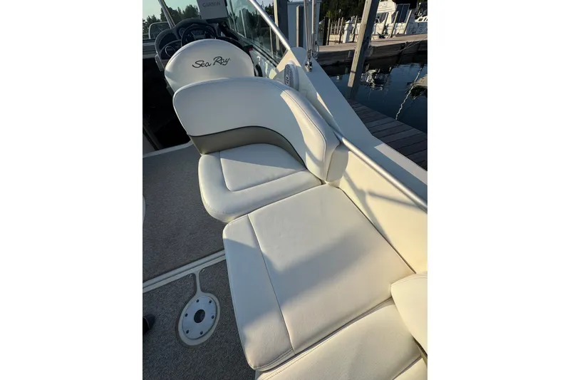 Slide: The Image of 2006 Searay 260 boat interior with white cushioned seating and steering wheel. - 18