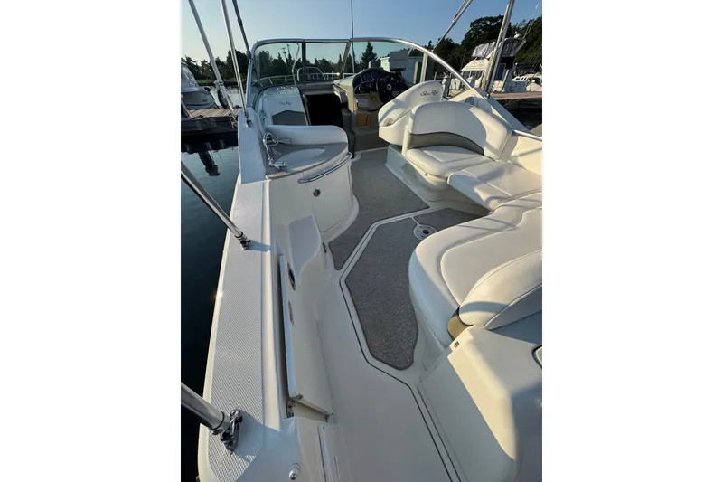 Slide: The Image of 2006 Searay 260 boat interior with white seating and helm, docked in sunlight. - 12