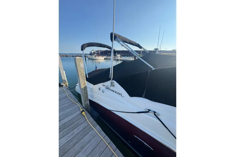 Slide: The Image of 2006 Searay 260 boat docked at marina under clear blue sky. - 2