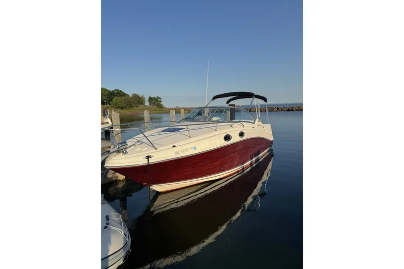 The Image of 2006 Sea Ray 270 Sundancer boat docked on calm water under clear sky. - 1