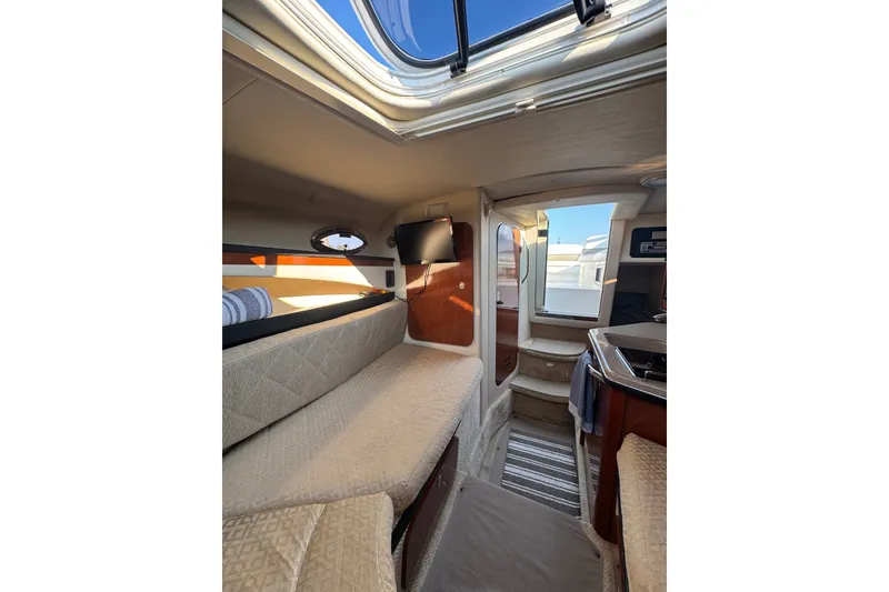 Slide: The Image of Interior of a 2006 Searay 260 boat, featuring cozy seating and modern amenities. - 30