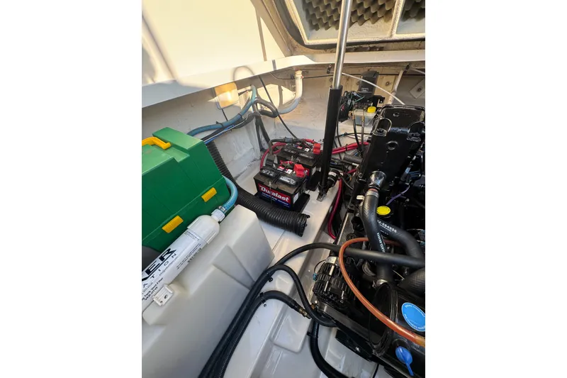 Slide: The Image of Engine compartment of a 2006 Searay 260 boat, featuring battery and wiring. - 24
