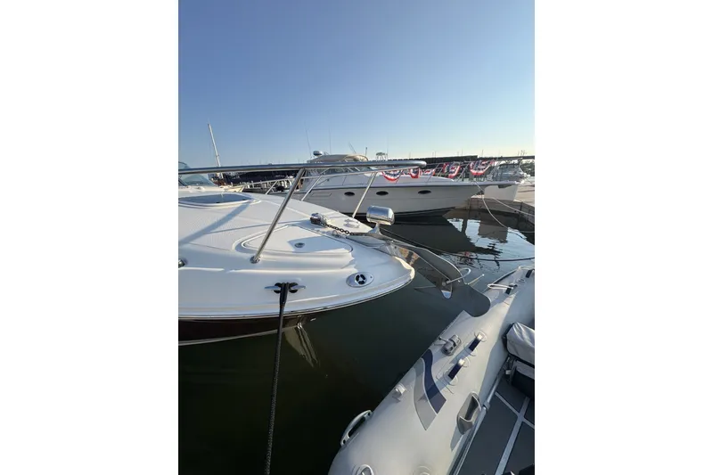 Slide: The Image of 2006 Sea Ray 270 Sundancer docked at marina, clear sky background. - 7