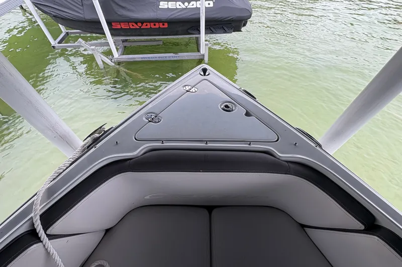 Slide: The Image of Bow of a 2021 Crownline 290 SS boat docked near a Sea-Doo, on calm water. - 25