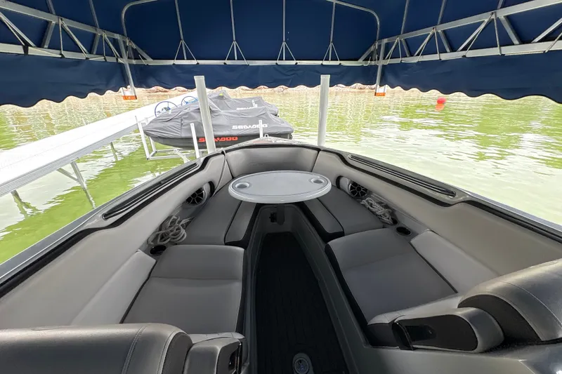 Slide: The Image of 2021 Crownline 290 SS boat interior with seating and table under canopy. - 24