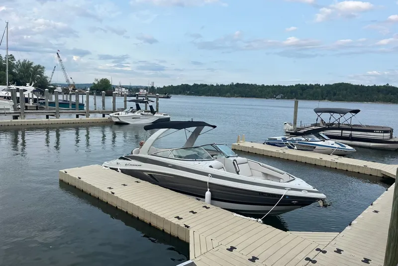 The Image of 2021 Crownline 290 SS boat docked at a marina with scenic waterfront views. - 7