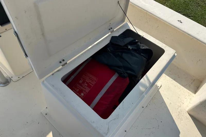 Slide: The Image of Open storage compartment on 2004 Jones Brothers Bateau 20 boat with life jackets inside. - 21