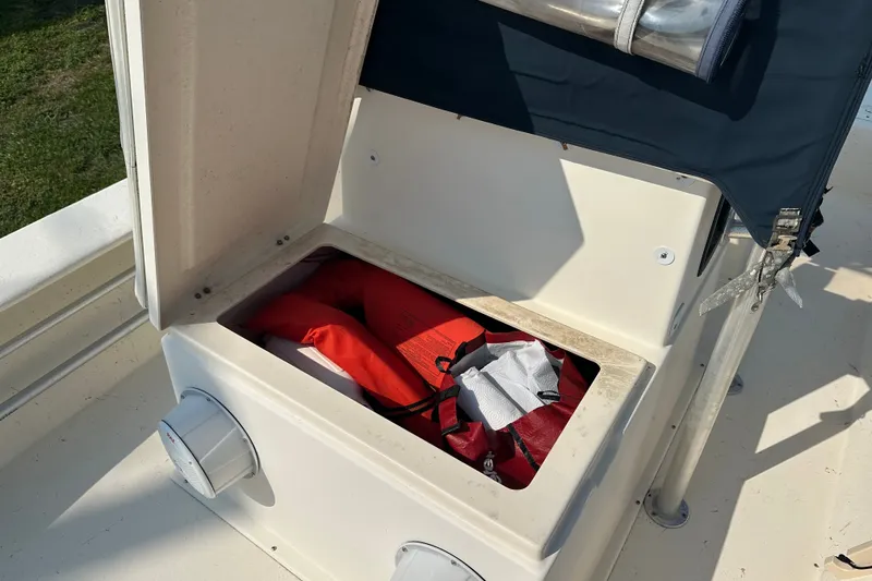 Slide: The Image of Open storage compartment on 2004 Jones Brothers Bateau 20 boat, containing life jackets. - 16