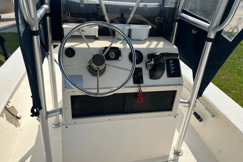 Slide: The Image of Center console of a 2004 Jones Brothers Bateau 20 boat with steering wheel and controls. - 18