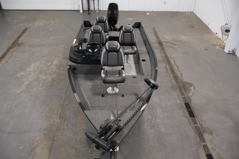 Slide: The Image of 2020 Lund 1650 Angler SS fishing boat with seating and trolling motor in a garage setting. - 9
