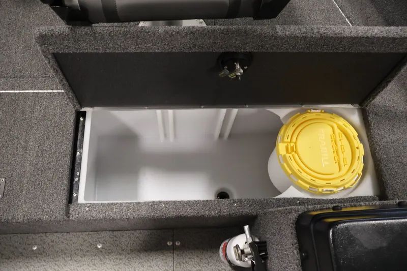 Slide: The Image of 2020 Lund 1650 Angler SS boat storage compartment with yellow lid and gray interior. - 20