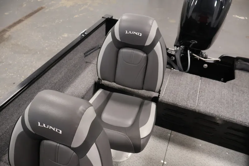 Slide: The Image of 2020 Lund 1650 Angler SS boat interior with gray seats and motor. - 31