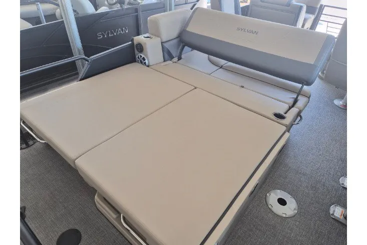 Slide: The Image of 2026 Sylvan X3 DLZ DH BAR boat interior with beige seating and speaker system. - 16
