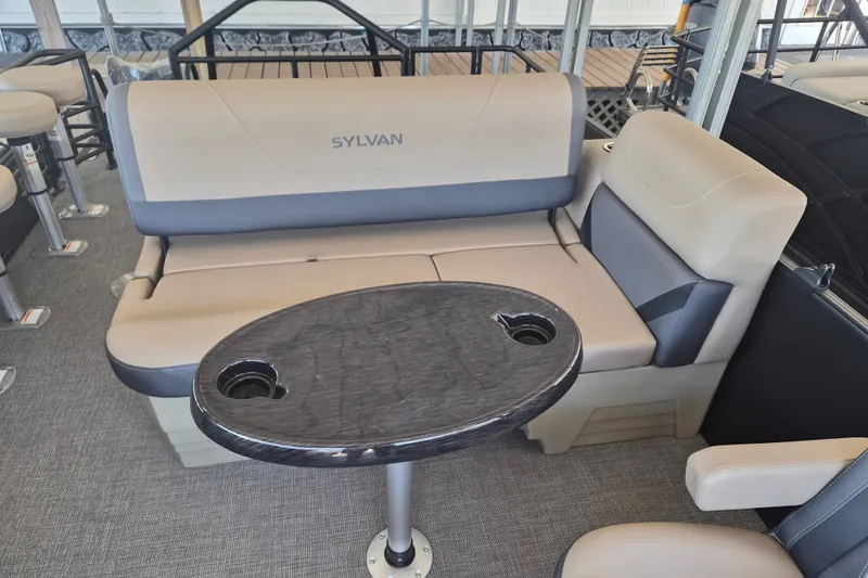 Slide: The Image of Luxurious seating area on 2026 Sylvan X3 DLZ DH BAR pontoon boat with table and cup holders. - 10