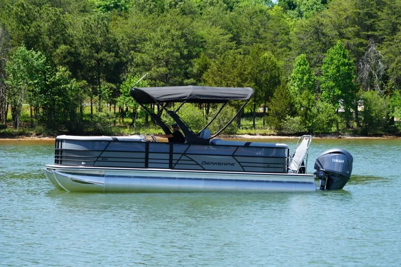 Slide: The Image of 2026 Berkshire 24RFX CTS pontoon boat on a serene lake with lush green trees. - 3
