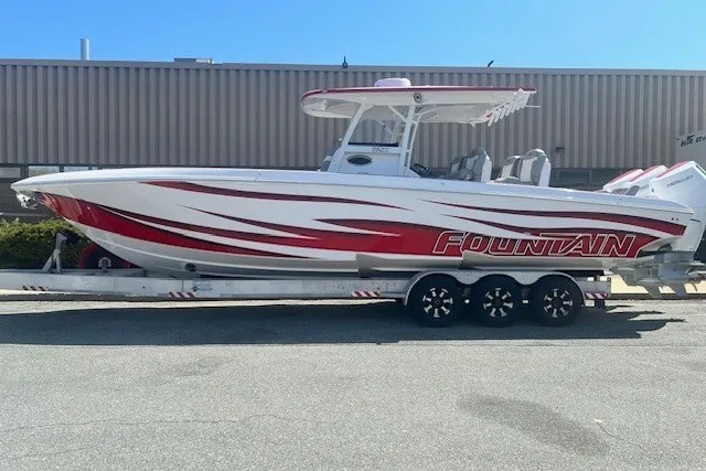 The Image of The image shows a 2025 Fountain 34 SC boat with a striking red and white design on a trailer. - 0