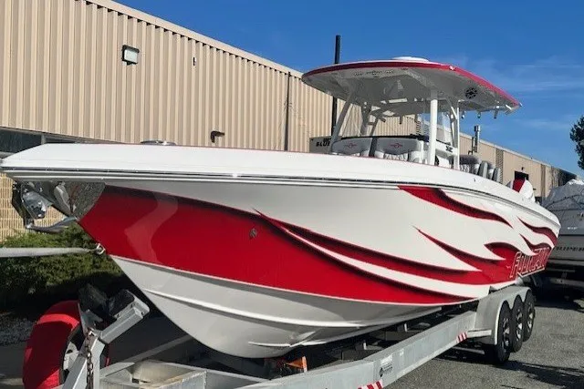 Slide: The Image of 2025 Fountain 34 SC boat with red and white design on a trailer. - 4