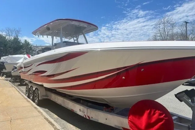 Slide: The Image of 2025 Fountain 34 SC boat with red and white design on a trailer, under a clear sky. - 5