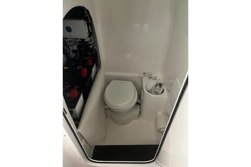 Slide: The Image of 2025 Fountain 34 SC boat interior with compact marine toilet and storage area. - 20