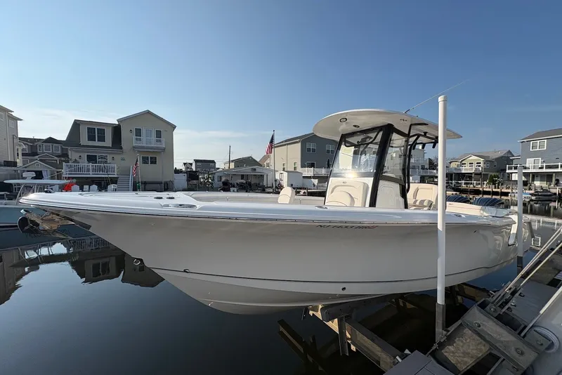 Slide: The Image of 2022 Sea Hunt Ultra 275SE boat docked in a residential marina setting. - 0