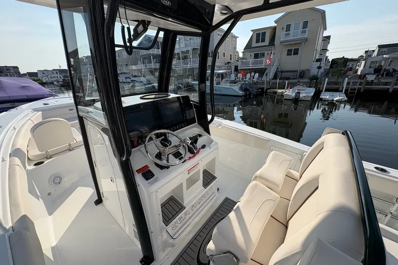 Slide: The Image of 2022 Sea Hunt Ultra 275SE boat interior with helm, seats, and waterfront view. - 8