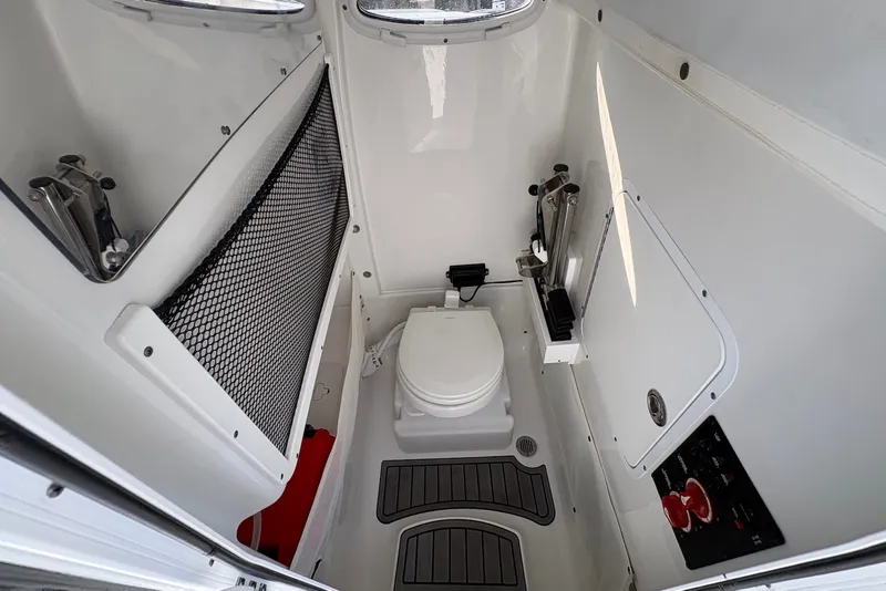 Slide: The Image of 2022 Sea Hunt Ultra 275SE boat interior with compact marine toilet and storage. - 13