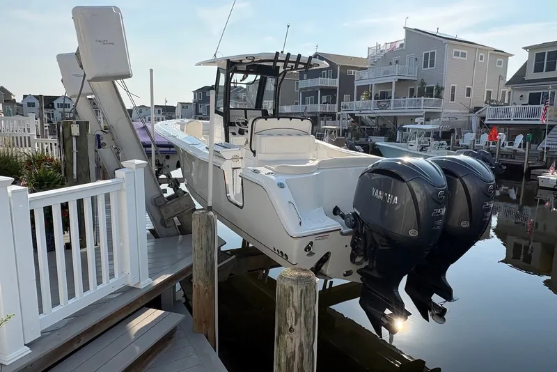 Slide: The Image of 2022 Sea Hunt Ultra 275SE boat docked with dual Yamaha engines in a residential marina. - 1
