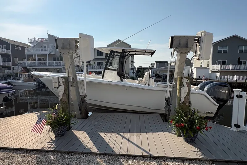 The Image of 2022 Sea Hunt Ultra 275SE boat docked in a residential marina setting. - 2