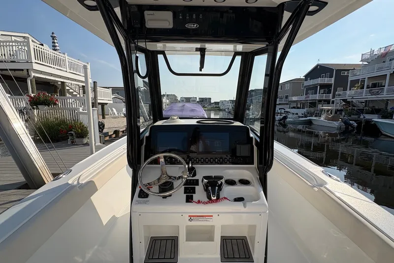 Slide: The Image of 2022 Sea Hunt Ultra 275SE boat cockpit with modern controls and waterfront view. - 6