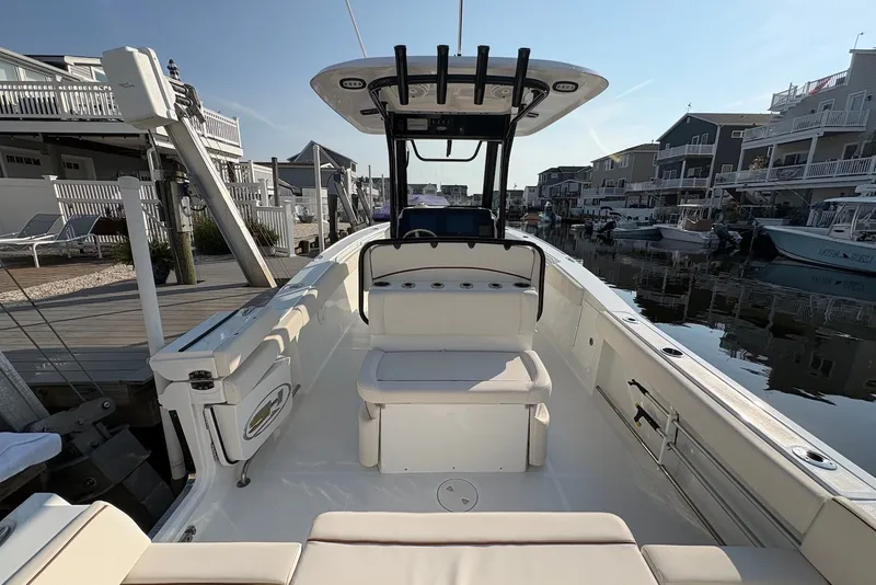 Slide: The Image of 2022 Sea Hunt Ultra 275SE boat docked in a marina, showcasing spacious seating and modern design. - 7