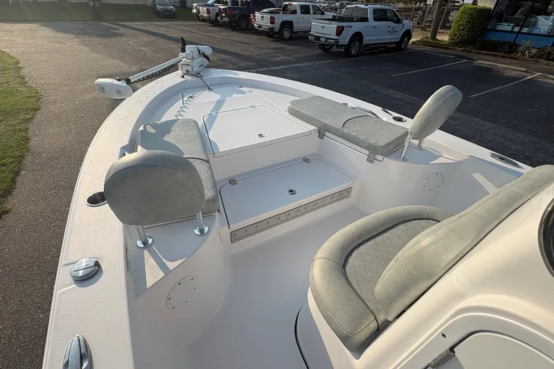 Slide: The Image of 2019 Sportsman Masters 227 Bay Boat interior with seating and storage in a parking lot. - 19