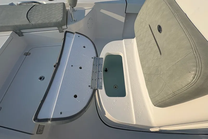 Slide: The Image of 2019 Sportsman Masters 227 Bay Boat interior with cushioned seating and storage compartment. - 21