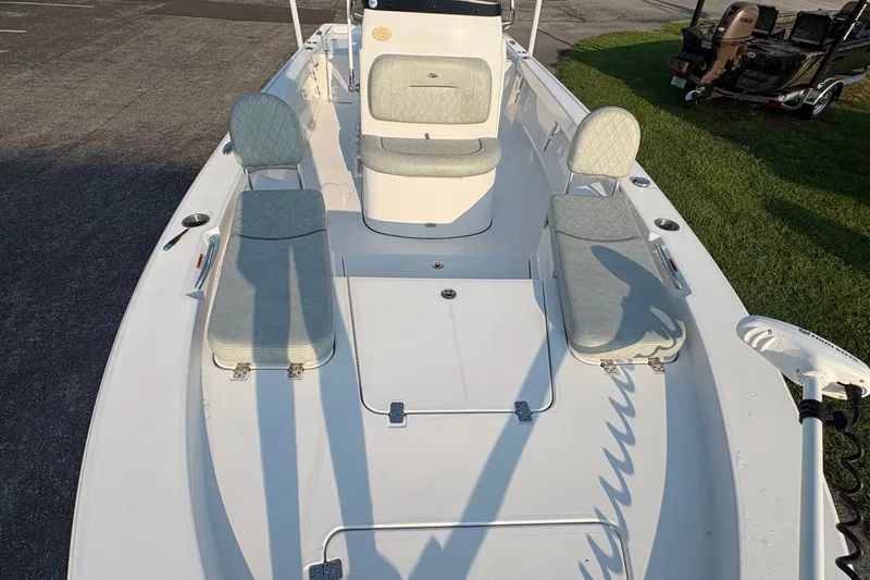 Slide: The Image of 2019 Sportsman Masters 227 Bay Boat interior with cushioned seating and storage compartments. - 23