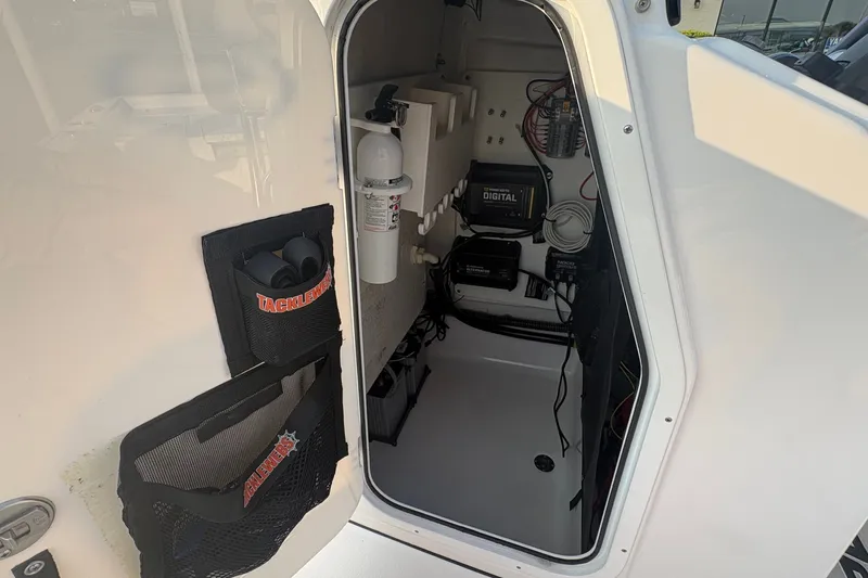 Slide: The Image of 2019 Sportsman Masters 227 Bay Boat storage compartment with tackle storage and electrical components. - 18