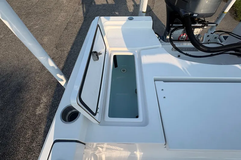 Slide: The Image of 2019 Sportsman Masters 227 Bay Boat with open storage compartment and visible engine. - 11
