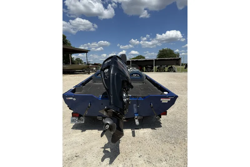 Slide: The Image of 2014 Lowe Stinger 175 boat with outboard motor, parked under a clear blue sky. - 4