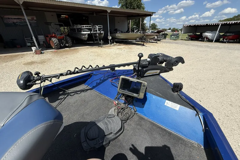 Slide: The Image of 2014 Lowe Stinger 175 boat with navigation equipment and motor in a storage area. - 7